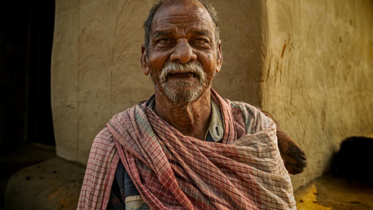 Portrait of a smiling elderly man in Jhargram, West Bengal, India, showcasing traditional clothing.