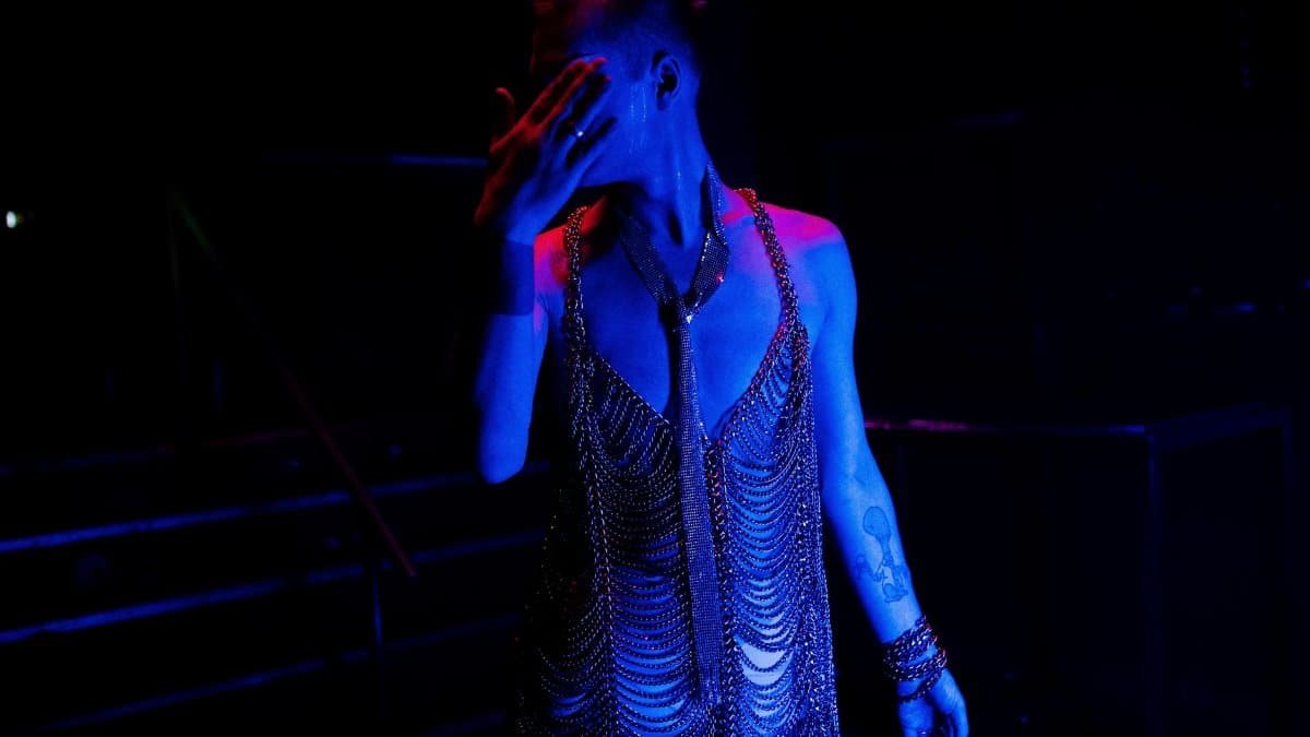 Capturing the vibrant transformation and glamour of a drag queen during a nightclub performance.