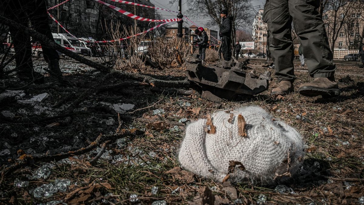 A chaotic urban scene depicting destruction with a knitted hat lying on the ground in Kyiv, Ukraine.