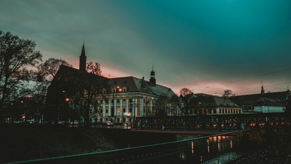 Twilight view of historic buildings along a river in a serene European cityscape.