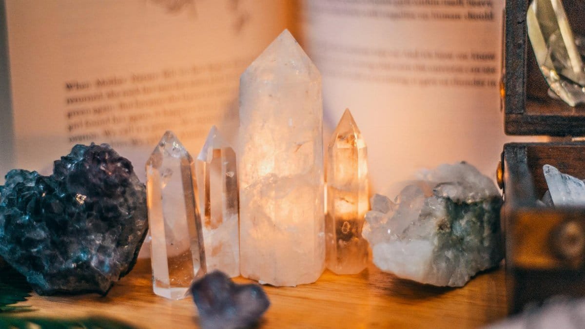 Close-up of various healing crystals on a wooden table with warm lighting