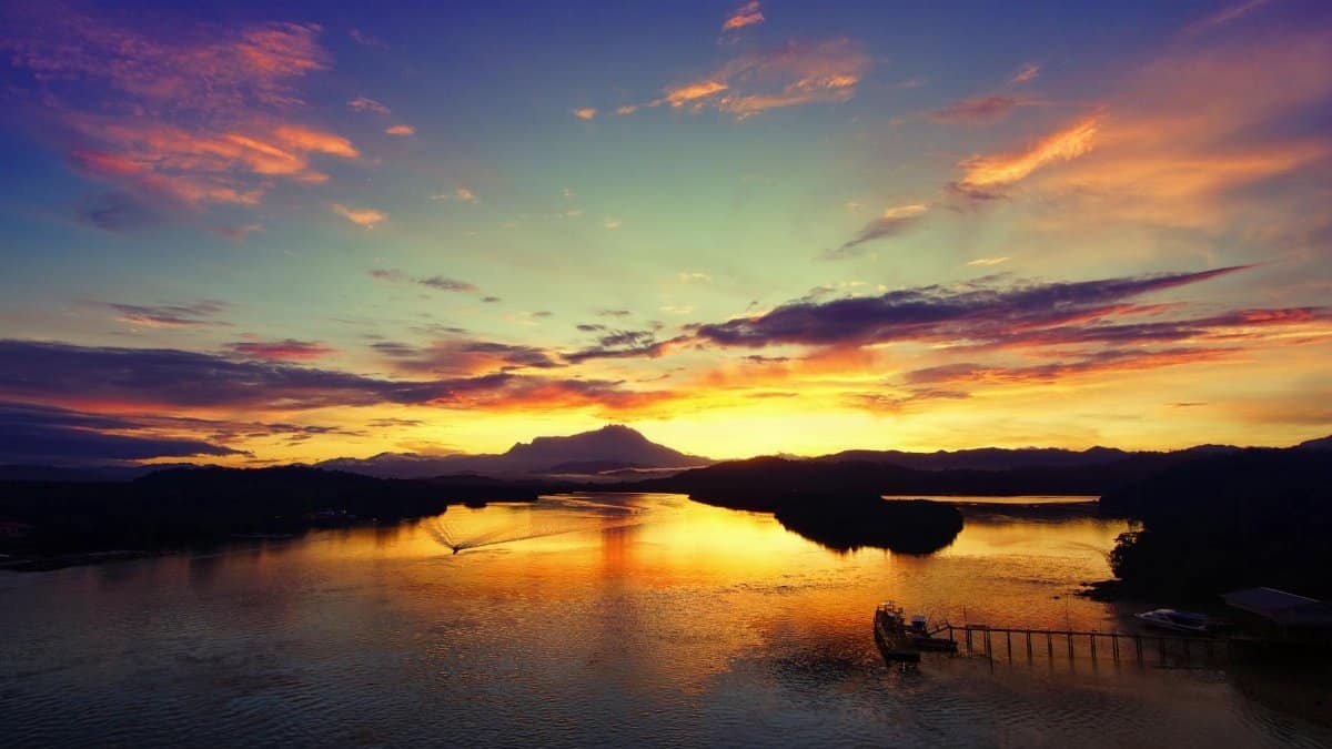 Mesmerizing sunset over a river in Tuaran, Sabah, Malaysia with vibrant sky and reflections.
