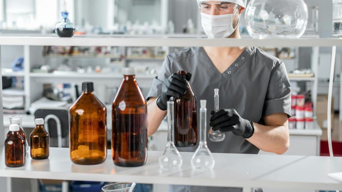 A biochemist wearing safety gear analyzes liquids in a state-of-the-art lab.