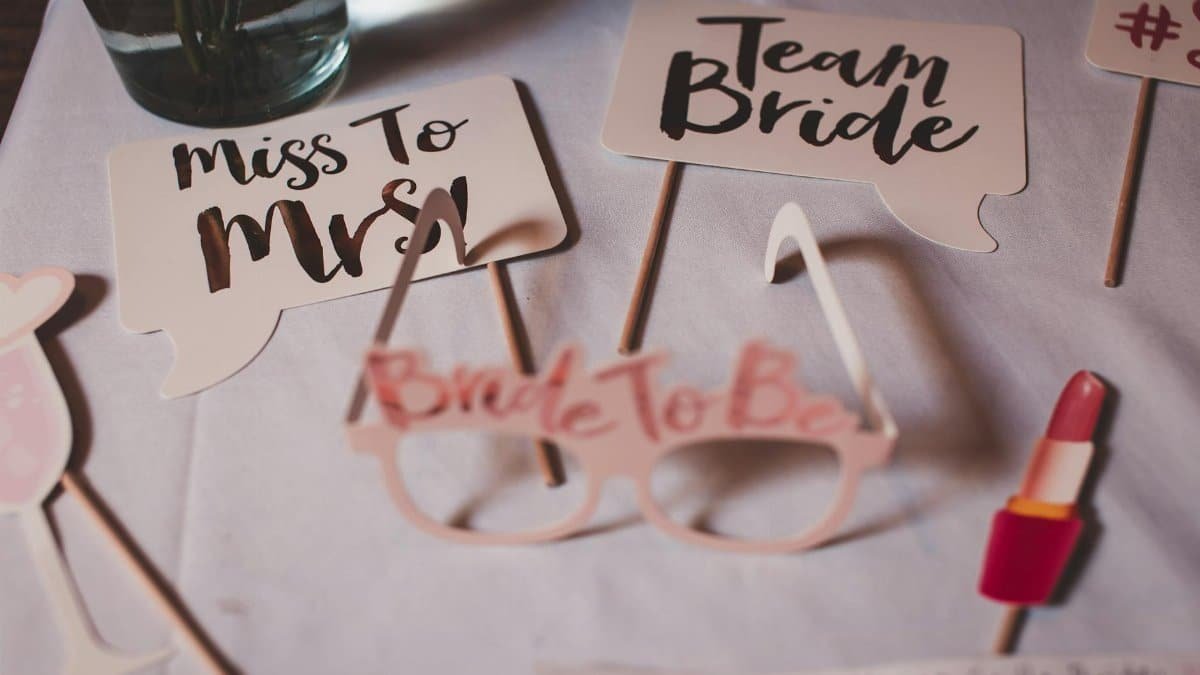 Flat lay of bridal shower decorations with creative signs and props.