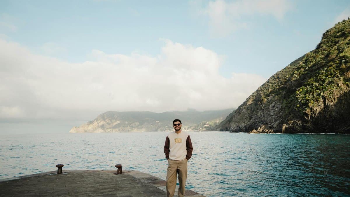 Young man on pier with stunning coastal views and clear skies.