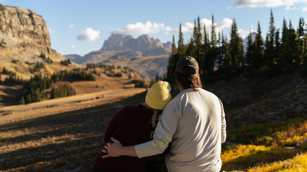 A couple embraces while enjoying a scenic mountain view at Grand Teton National Park, Wyoming.