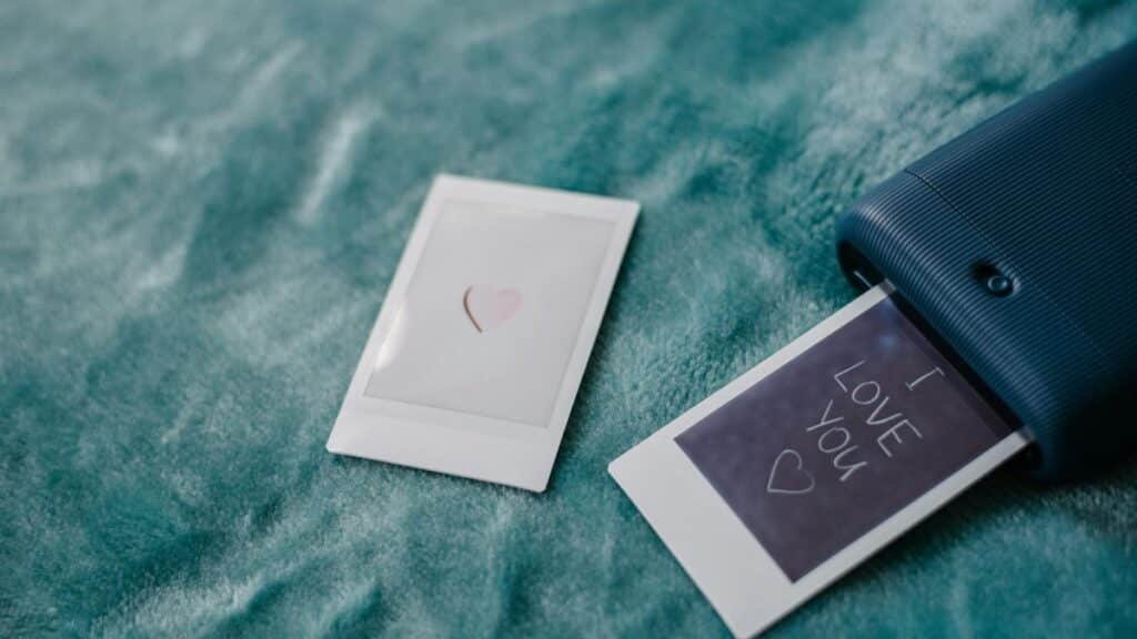 Instant photo printer creating a romantic 'I Love You' message, ideal for Valentine's Day themes.