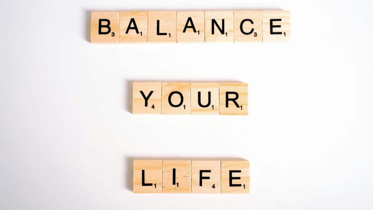 Inspirational message 'Balance Your Life' made with Scrabble tiles on a white background.
