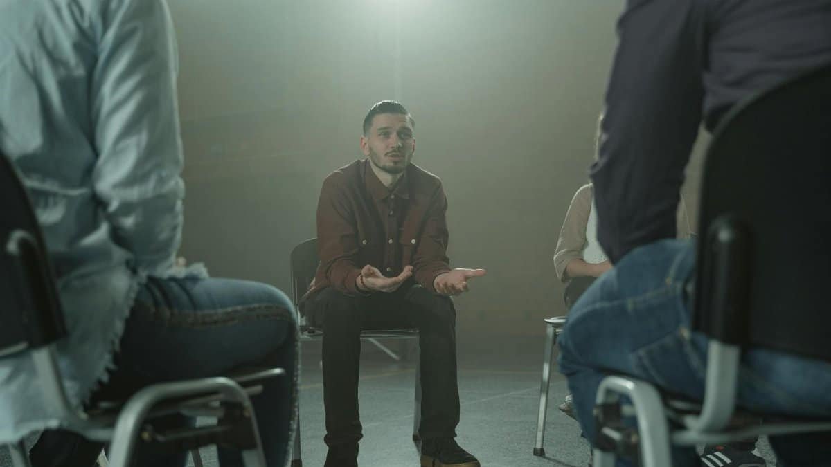 A group therapy session indoors with diverse adults in a supportive environment.