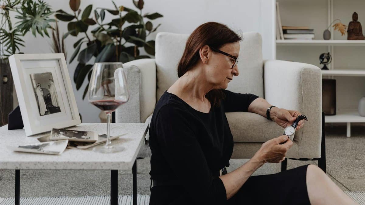 Elderly woman in a contemplative moment indoors, surrounded by memories.