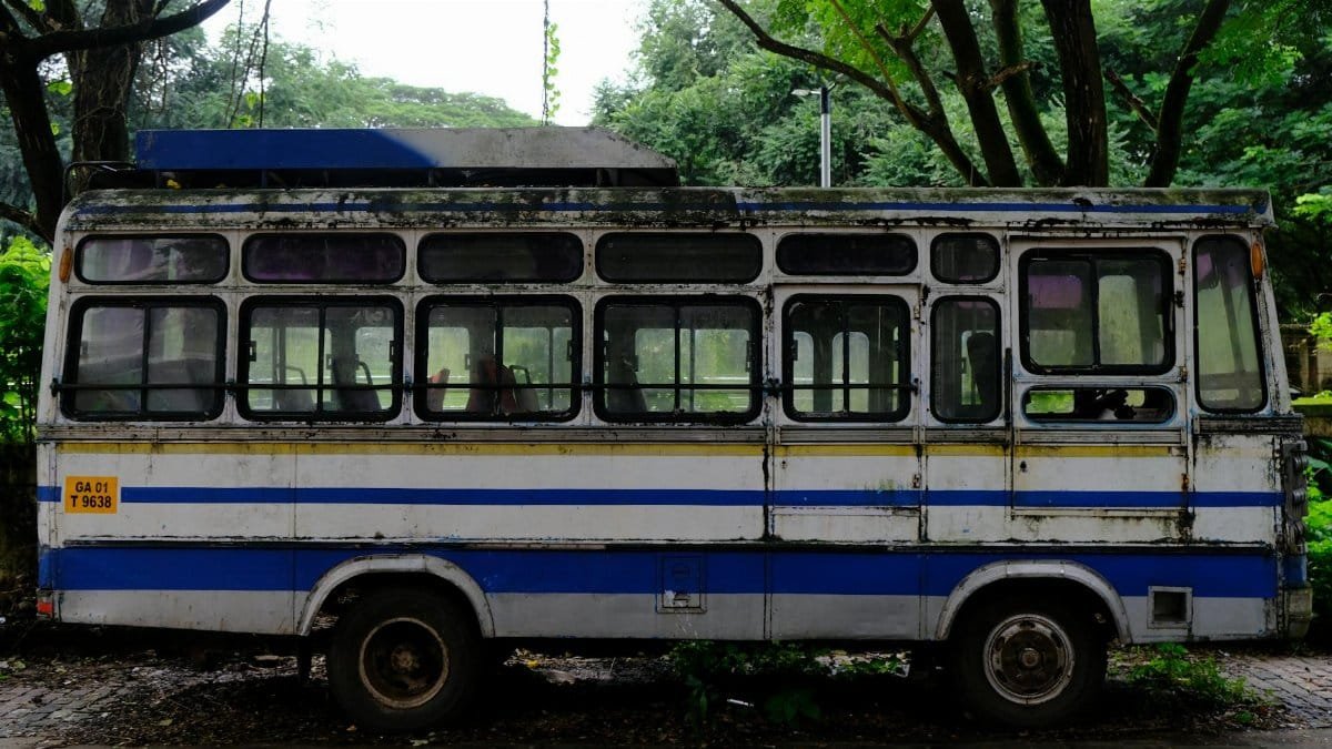 A vintage blue and white bus parked under trees in Goa, India. Ideal for travel and nostalgia themes.