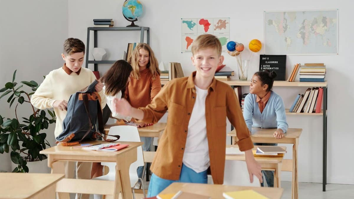 Cheerful students enjoying a break in a lively, diverse classroom setting.