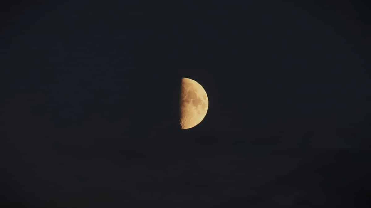 Beautiful half moon set against a deep, dark sky, evoking a serene and calm night atmosphere.