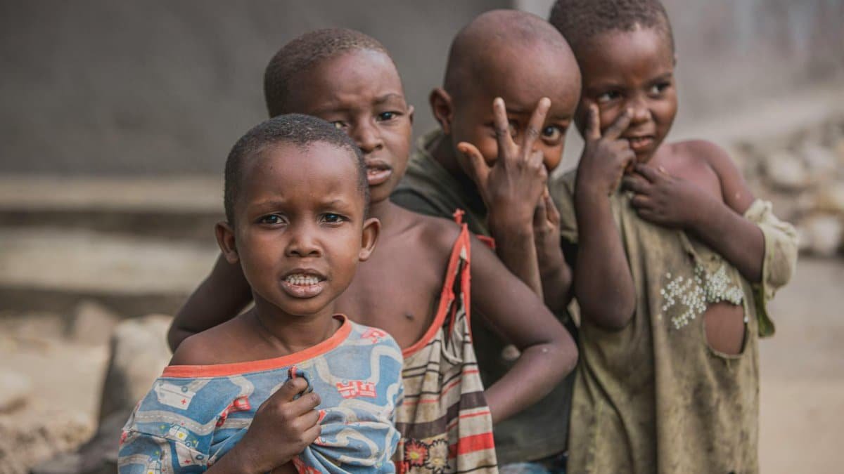 A group of children displaying cheerful expressions while posing outdoors.