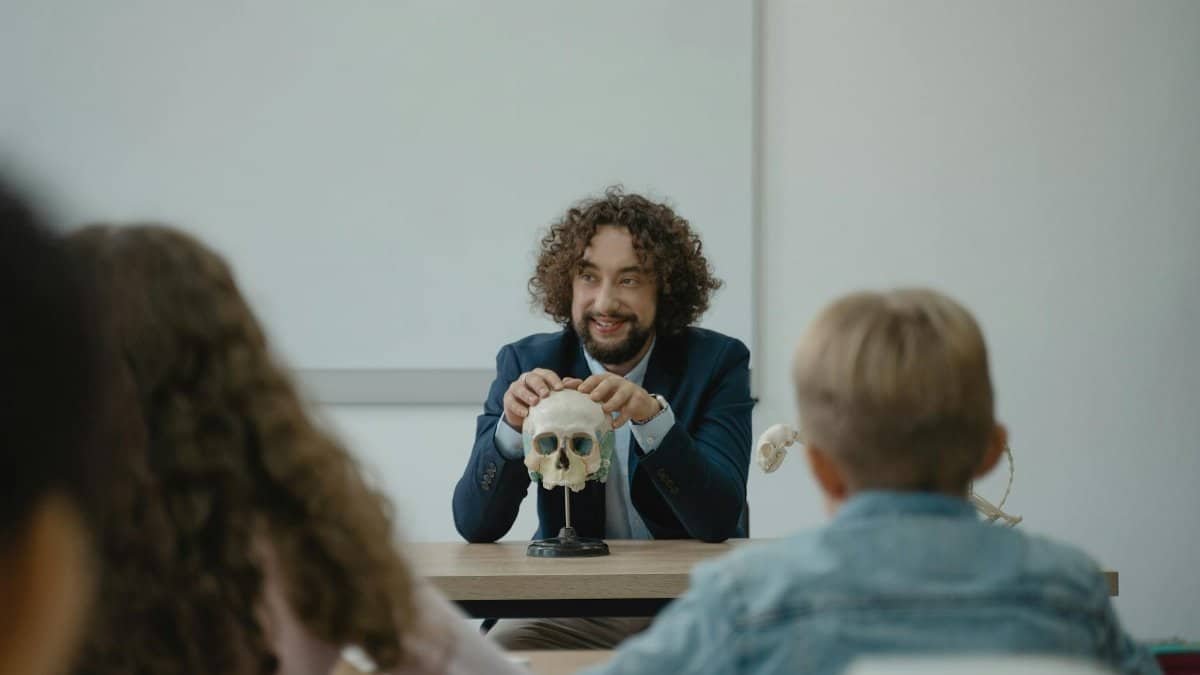 Teacher engaging students with a skull model in an interactive biology lesson.