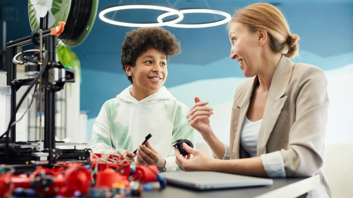 Child and adult engaged in STEM activity with 3D printer indoors.
