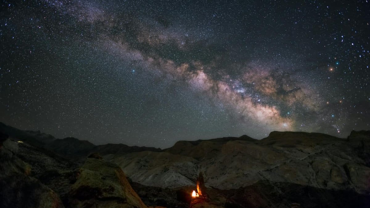 Stunning Milky Way view over mountains in Himachal Pradesh with a cozy campfire.