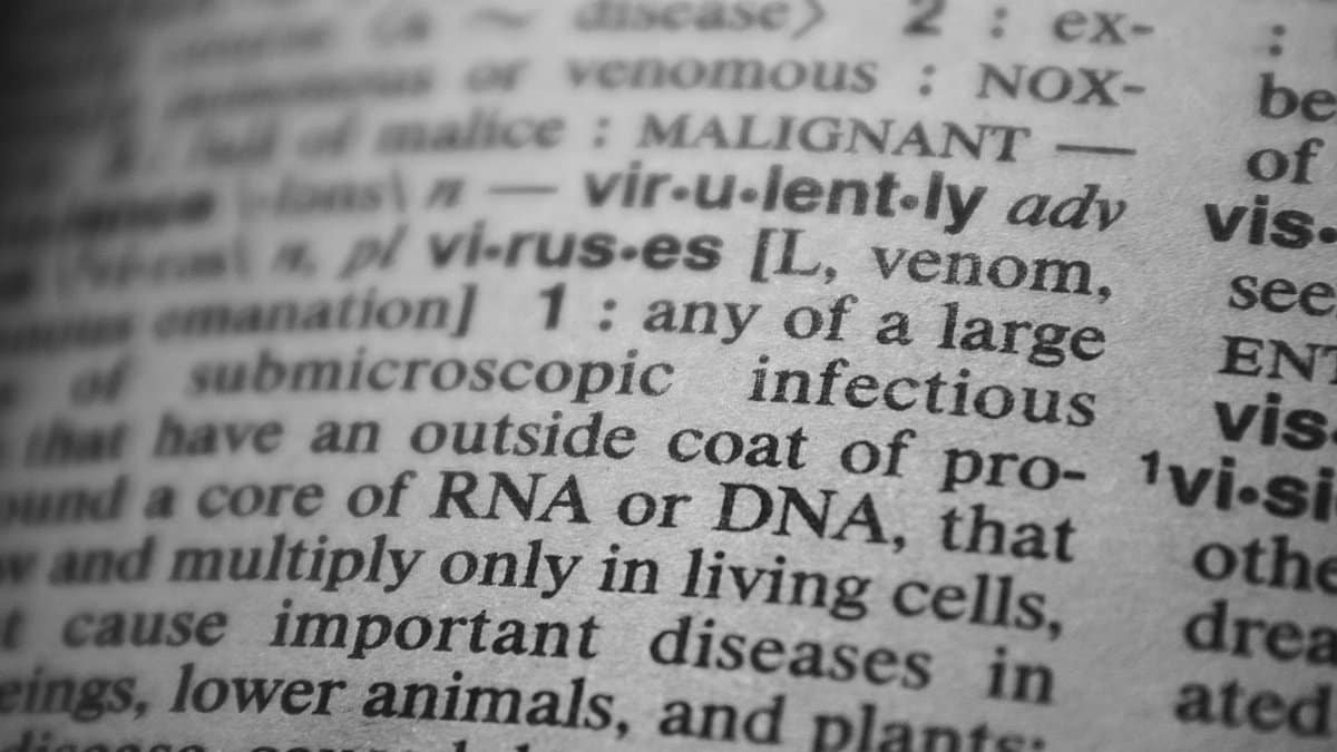 Black and white close-up of a dictionary page focusing on the definition of 'virus'.