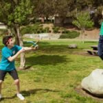 Two boys having fun and playing games outdoors during summer camp.