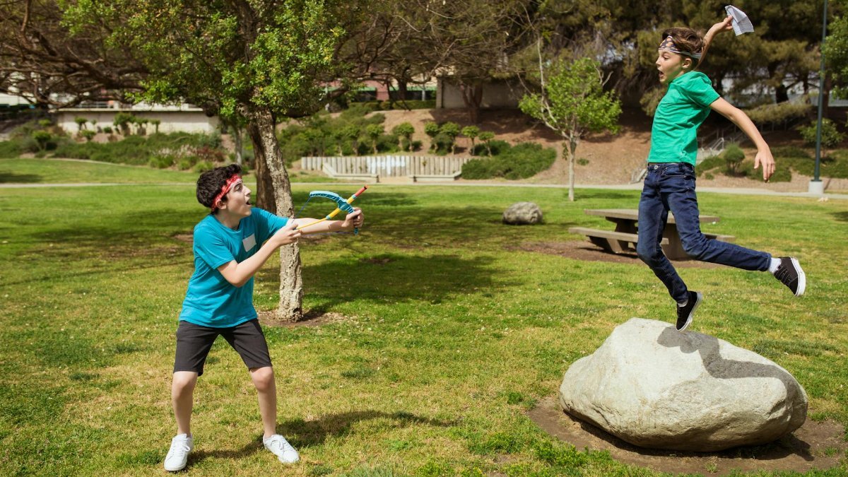 Two boys having fun and playing games outdoors during summer camp.