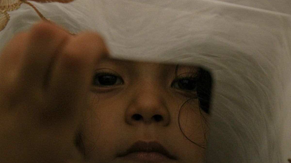 Close-up of a child gazing at their reflection in a mirror in Gigante, Huila, Colombia.