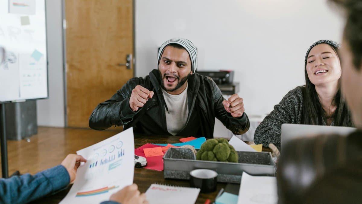 Energetic office meeting showcasing teamwork and innovative idea sharing among young entrepreneurs.