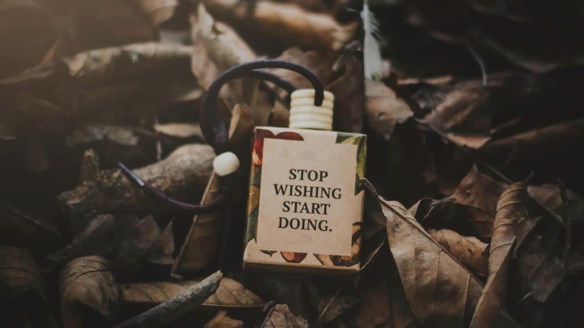 A box with a motivational quote amid dry autumn leaves, inspiring action.