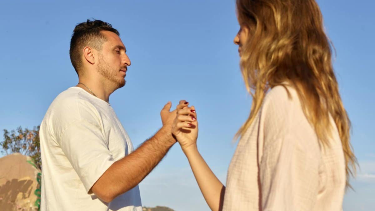 A man and woman holding hands in a serene outdoor setting, symbolizing connection and mindfulness.
