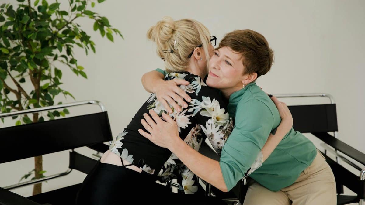 Two women sharing a comforting hug in a therapy session, symbolizing trust and support.