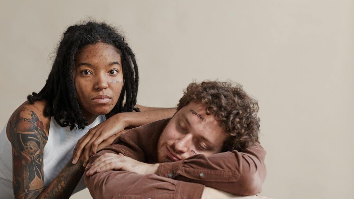 Interracial couple embracing relaxation with positive self-image messages in indoor setting.