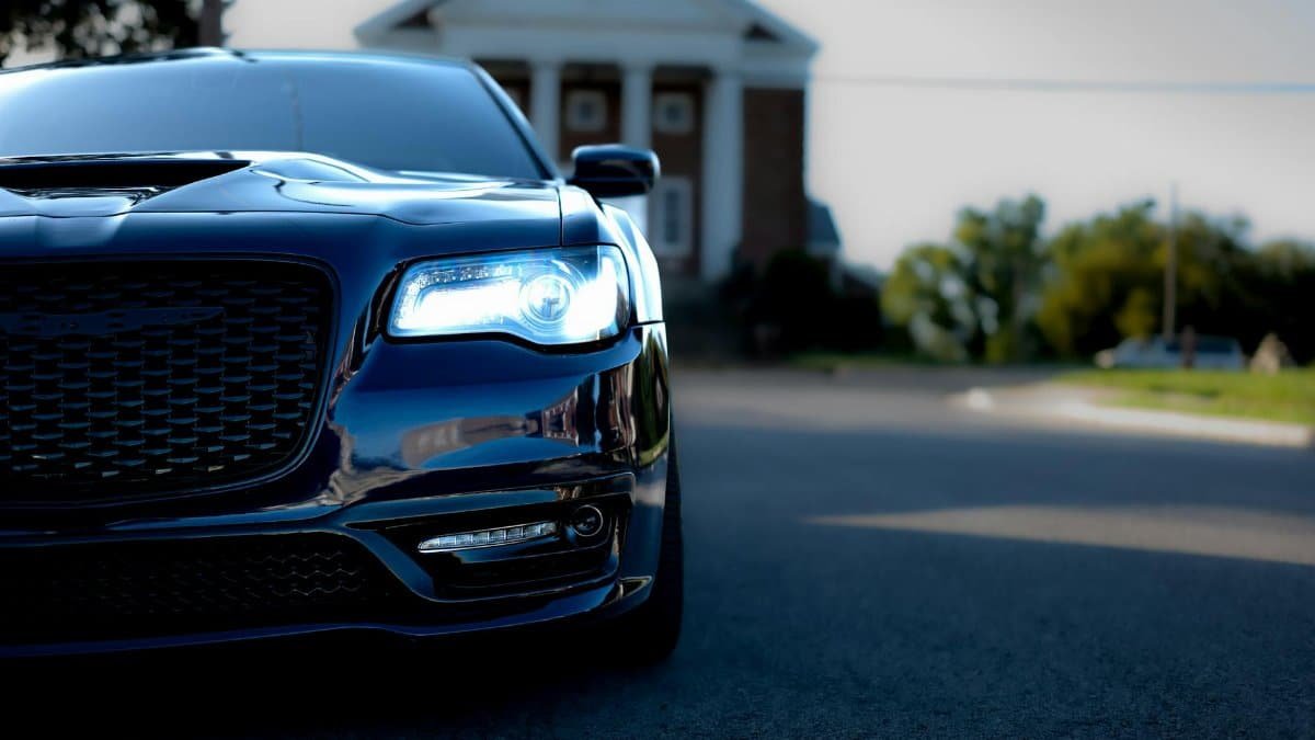 Elegant blue car with LED lights showcased on a clear day in an urban environment.