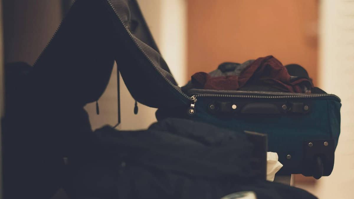 A warm-toned indoor image of an open suitcase with clothes, conveying travel readiness.