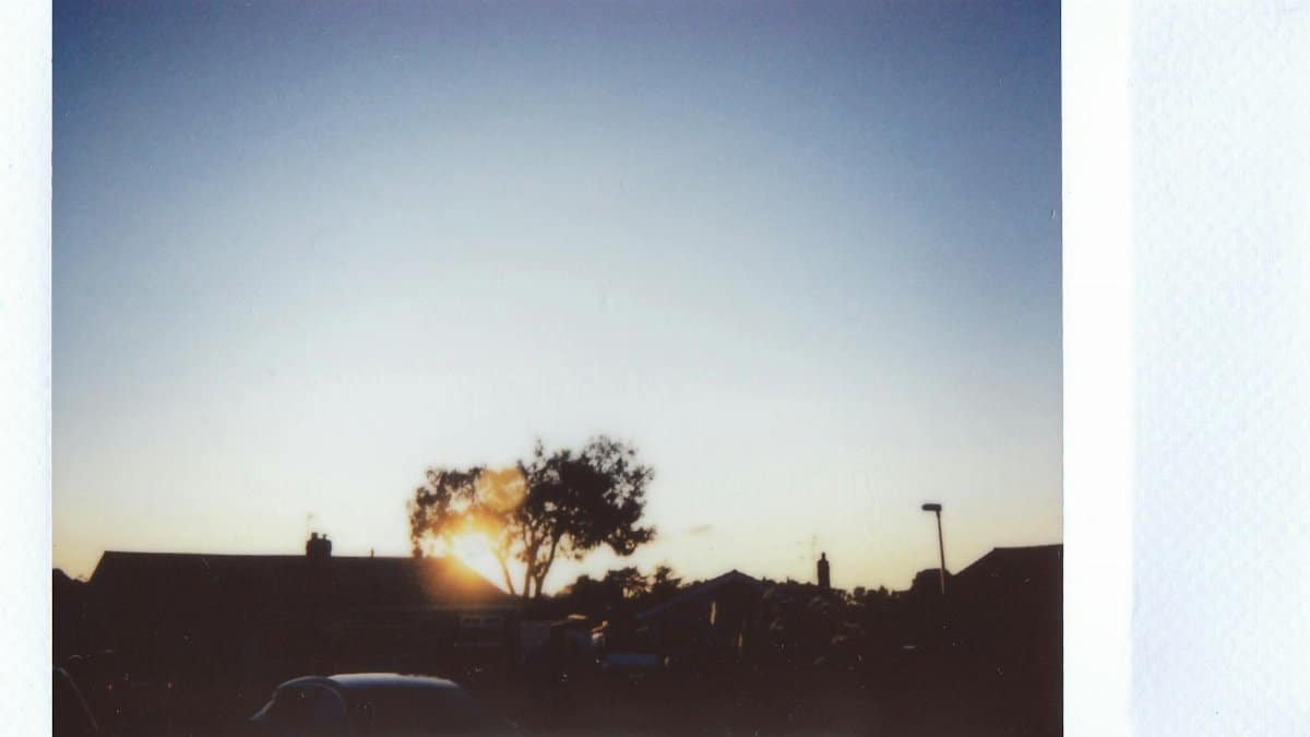 Silhouette of houses and trees against a scenic sunset, creating a serene and tranquil atmosphere.