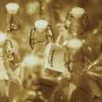 Closeup of empty glass bottles with white stoppers on display.