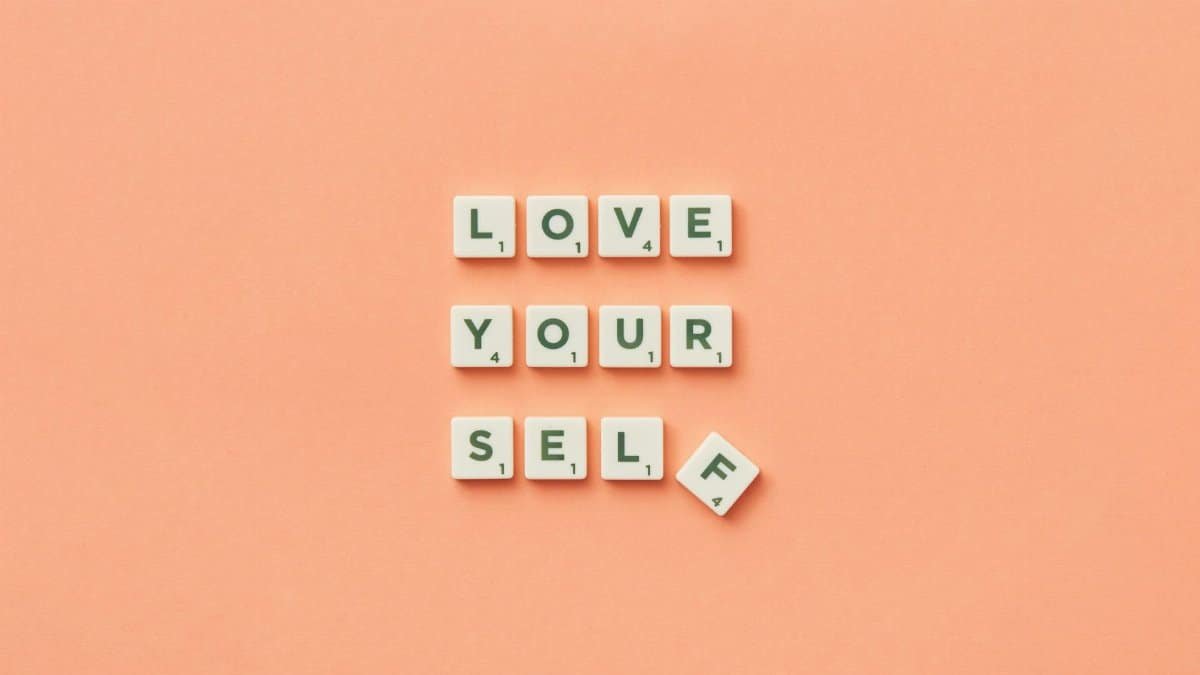 Scrabble tiles spelling 'Love Yourself' on a peach background, inspiring self-care.