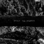 Black and white image featuring 'Enjoy the Silence' text on a tree branch in a forest setting.