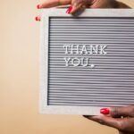 Close-up of hands holding a thank you sign, perfect for expressing gratitude.