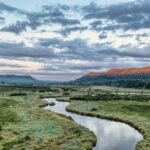 A peaceful landscape featuring a winding river and distant hills at dawn in Tell, Wisconsin.
