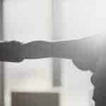 Silhouette of a female boxer throwing a punch in sunlight, capturing strength and focus.