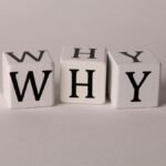 Close-up of lettered dice spelling 'WHY' on a neutral background, ideal for concepts of inquiry or curiosity.