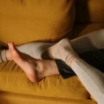 A couple snuggling together on a comfortable yellow sofa at home.