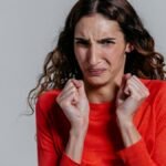 A woman displaying a disgusted facial expression indoors.