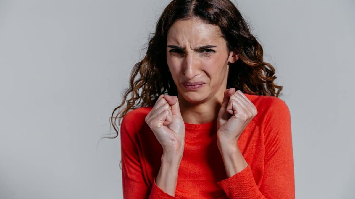A woman displaying a disgusted facial expression indoors.