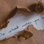 Brown paper revealing message 'Do what makes you happy.'