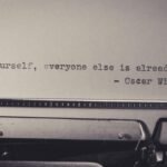 Vintage typewriter displaying Oscar Wilde's quote 'Be yourself, everyone else is already taken.'