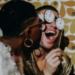 A joyful New Year's Eve party featuring friends in glamorous attire, celebrating indoors.