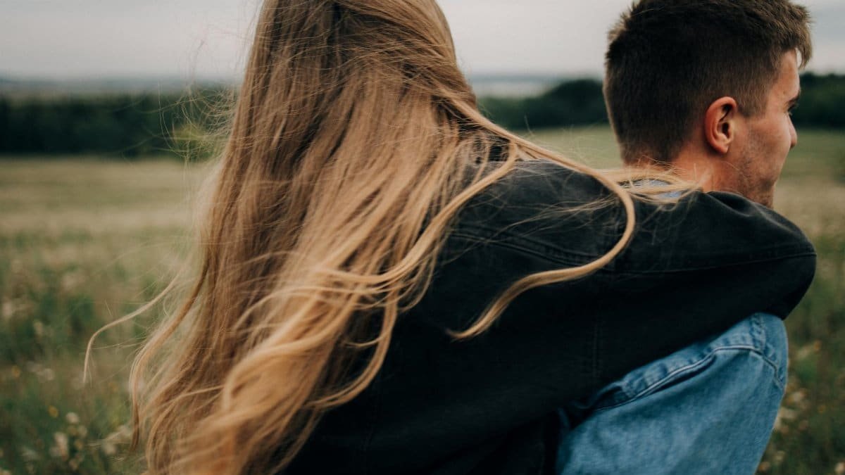 A couple embracing while enjoying a peaceful moment outdoors with nature as their backdrop.