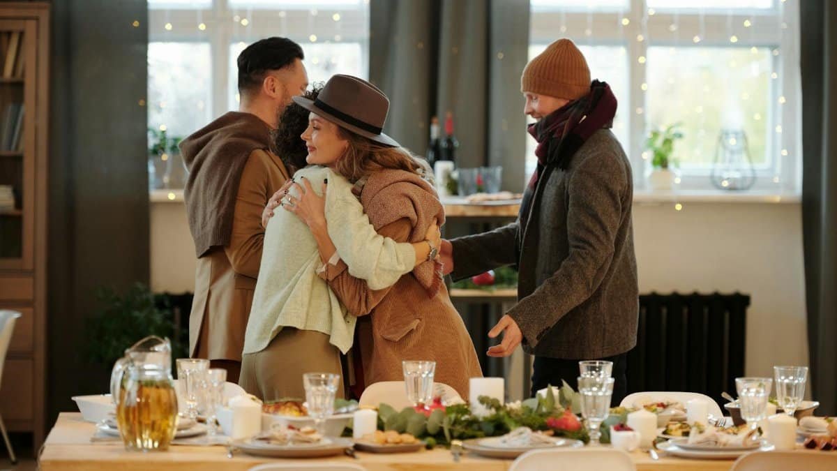 Family embracing and dining together indoors during festive holiday season.