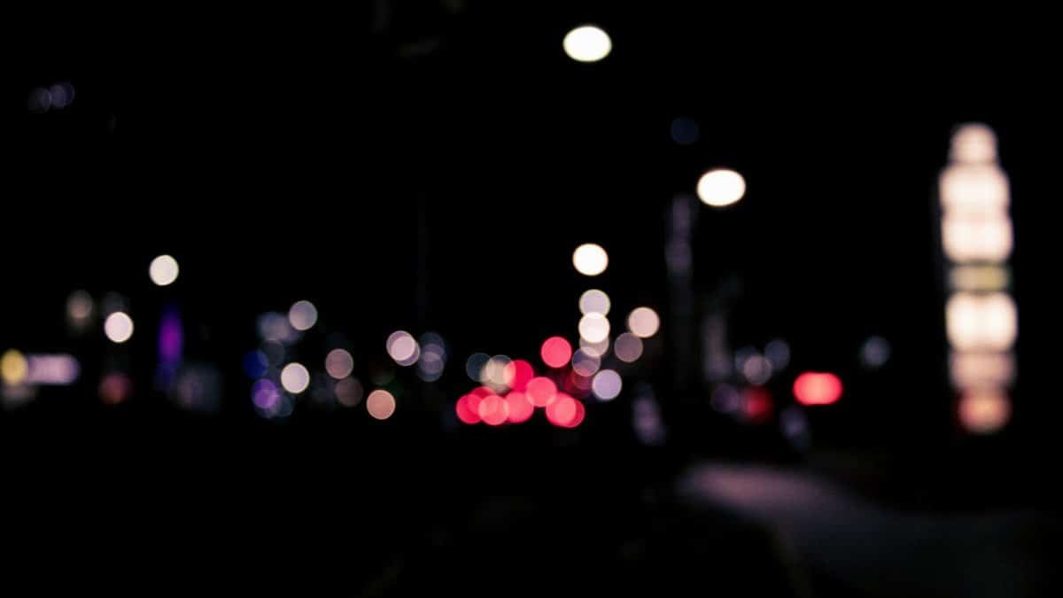 Blurred urban nighttime scene with colorful bokeh lights creating a dreamy effect.