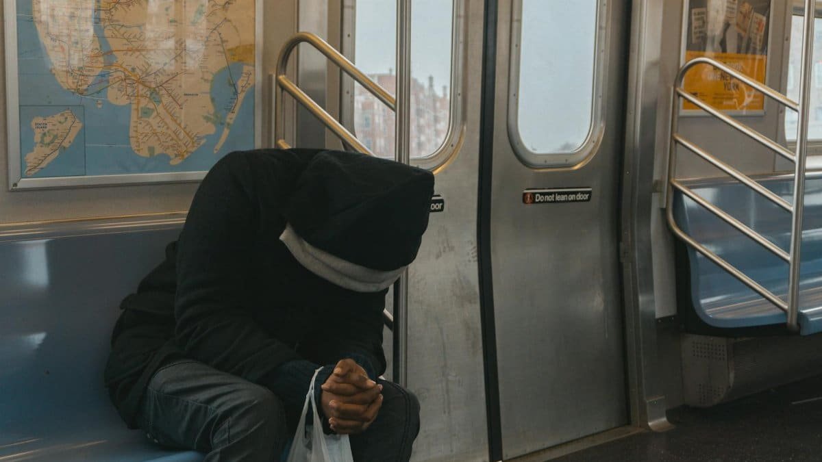 A lone passenger sitting in a New York City subway train, evokes feelings of solitude and reflection.